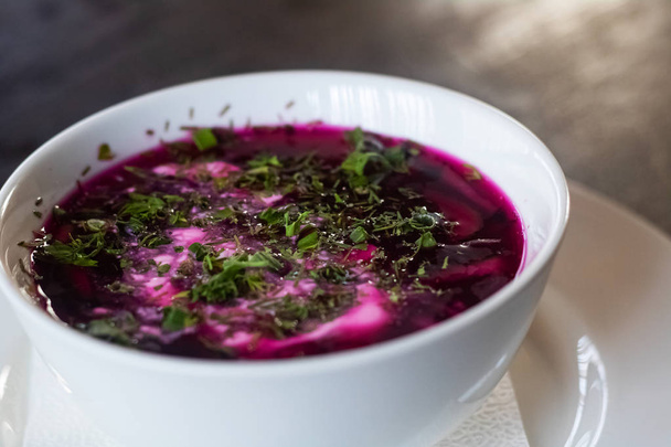 Beetroot soup in a plate on a wooden table - Photo, Image