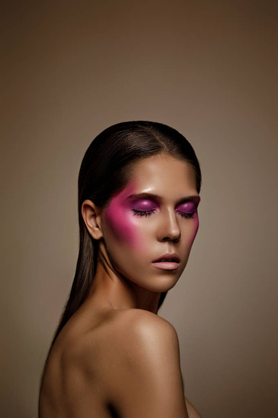 Fashion art skin woman face portrait closeup. Glamour shiny professional makeup girl with trendy pink make-up - 写真・画像
