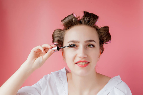 nice cheerful young the girl in the curler paints an eyebrow on  - 写真・画像