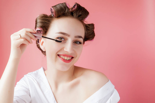 nice cheerful young the girl in the curler paints an eyebrow on  - 写真・画像