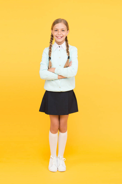 Confident students. knowledge day. childhood happiness. happy girl in school uniform. education concept. back to school. kid fashion. school market. smart little girl on yellow background - Foto, afbeelding