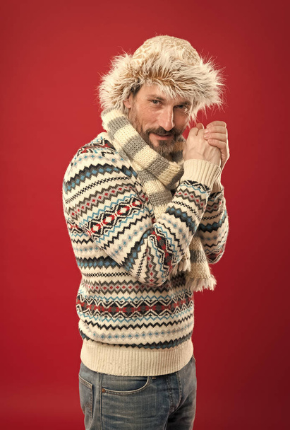 Suffering from cold. Bearded man accessorizing sweater with hat and scarf. A winter ensemble protects him from cold. Mature fashion model enjoys cold weather style. Winter wardrobe for stylish man - 写真・画像