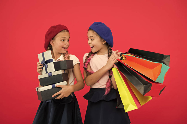 Discount and sale concept. Kids cute girls hold shopping bags. Shopping discount season. Special offer. Great day for shopping. Children enjoy shopping red background. Visiting clothing mall - Fotografie, Obrázek