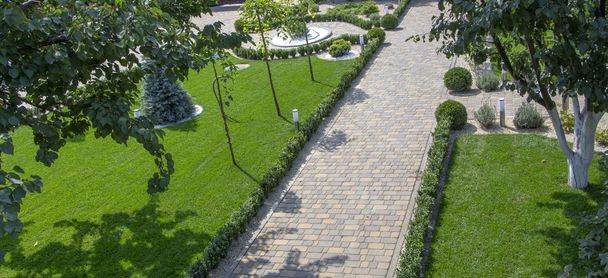 Geplaveide betonnen plakplaat track in een prachtig verzorgde tuin - Foto, afbeelding