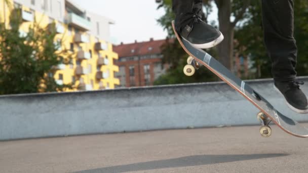 Lassú mozgás Bezárás: felismerhetetlen fiatal gördeszkás srác landol egy tökéletes kickflip a beton parkban. Menő korcsolyázó szórakozik a városban csinál egy flip trükk egy napsütéses napon. Cinematikus gördeszkázás - Felvétel, videó