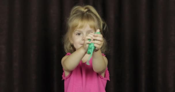 Παιδί που διασκεδάζει φτιάχνοντας πράσινη γλίτσα. Παιδί παίζοντας με το χέρι φτιαγμένο παιχνίδι λάσπη - Πλάνα, βίντεο