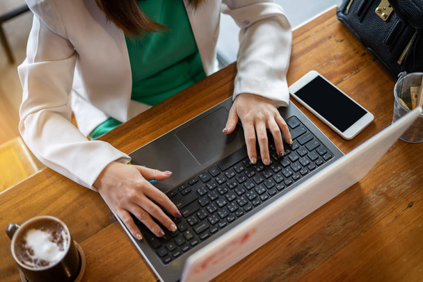 zakenvrouw werken met het gebruik van computer en smartphone in koffie - Foto, afbeelding