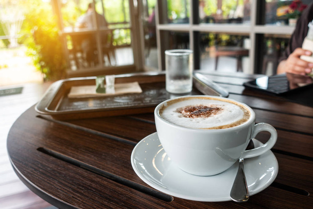 Ahşap masa üzerinde sıcak kapuçino kahve seramik fincan  - Fotoğraf, Görsel