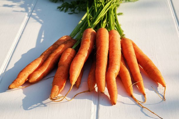 крупним планом свіжоспечена органічна морква на сільській дерев'яній стільниці, домашнє вирощування, рослинна основа, вид зверху
, - Фото, зображення