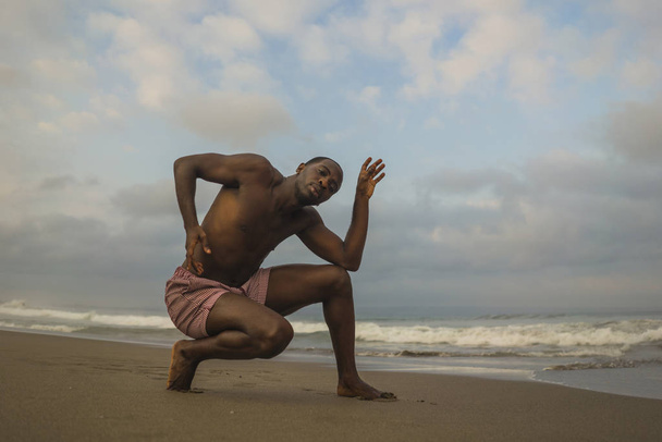contemporary dance choreographer and dancer doing ballet beach workout . a young attractive and athletic black African American man dancing in dramatic performance  - Fotó, kép
