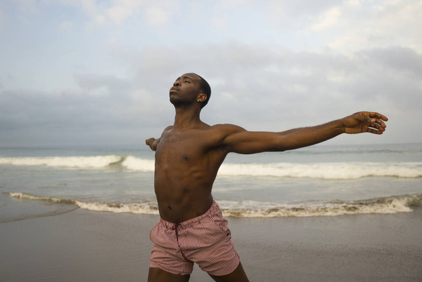 contemporary dance choreographer and dancer doing ballet beach workout . a young attractive and athletic black African American man dancing in dramatic performance  - Fotografie, Obrázek