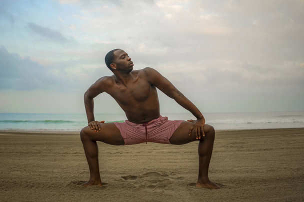 dramatic contemporary dance choreographer doing ballet beach workout, young attractive and athletic afro black American man dancing on sunrise  - Fotoğraf, Görsel