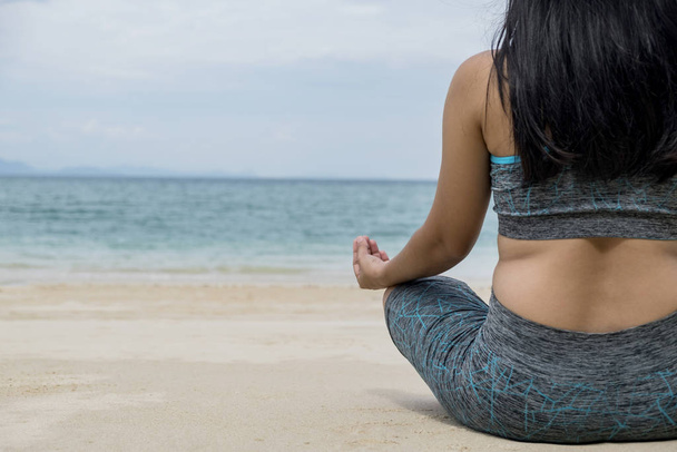 Jovem bela mulher saudável fazendo meditação na praia
 - Foto, Imagem