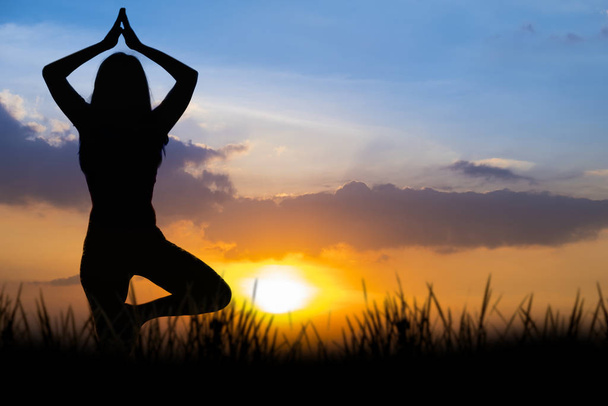 Silhouette Asia mujer yoga en la puesta del sol
. - Foto, Imagen