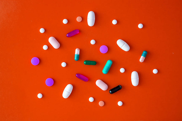 scattered various colored tablets in a red background. View from above. close-up - Photo, Image