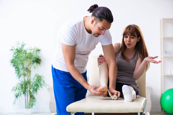 Leg injured woman visiting young doctor traumatologist - Foto, Bild