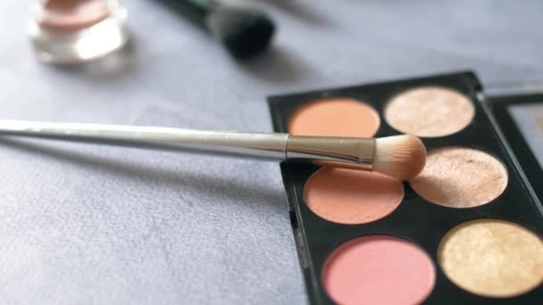 Vrouw cosmetica make-up dingen op textuur oppervlak. Oogschaduw palet en borstels met differents kleur poeders. 4k. - Video