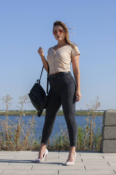 Portrait of young european woman is standing near the lake, beautiful european woman in nature. - Фото, зображення