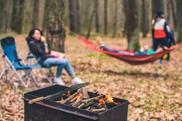 people resting outdoors. grill with fire close up. laying on hammock on background - Photo, Image