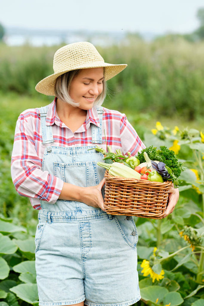 Mujer sosteniendo una cesta llena de hortalizas orgánicas de cosecha y raíz en la granja biológica Bio. Cosecha Vegetal de Otoño - Foto, Imagen