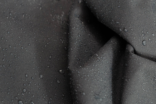 gris foncé imperméable hydrophobe froissé tissu gros plan avec gouttes de pluie mise au point sélective fond
 - Photo, image
