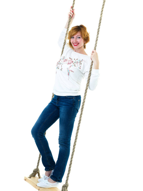 beautiful young woman on a swing against white studio backgroun - Fotoğraf, Görsel