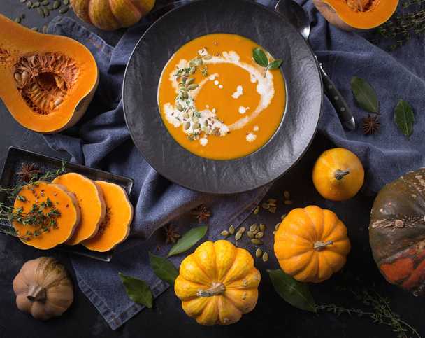 Pumpkin soup in a plate on a dark background - 写真・画像