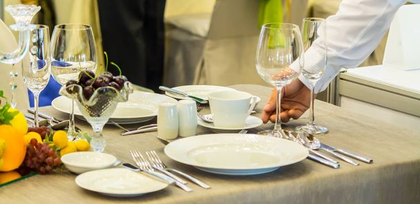 Camarero decorar y fijar mesa de cena de fiesta en el restaurante
 - Foto, imagen