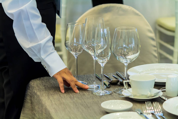 Číšník zdobí a nastavuje večerní stolek v restauraci - Fotografie, Obrázek