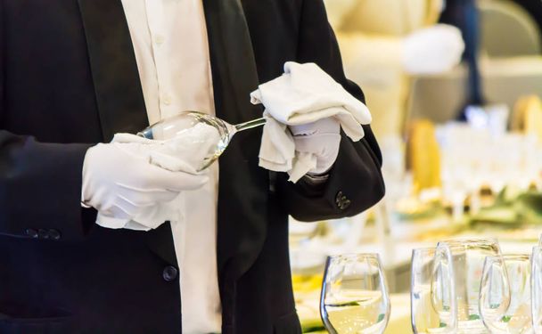 Camarero limpiando copa de vino para la decoración en la mesa
. - Foto, imagen