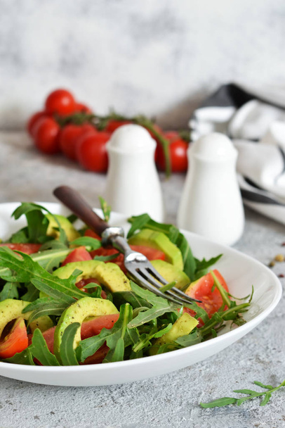 Salad with rucolla, tomatoes, avocado and sauce  - Foto, afbeelding