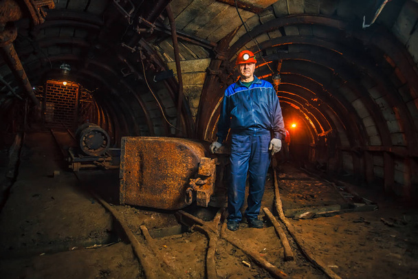 Kömür madeninde bir madenci tramvayın yanında duruyor. Kopyalama alanı. - Fotoğraf, Görsel
