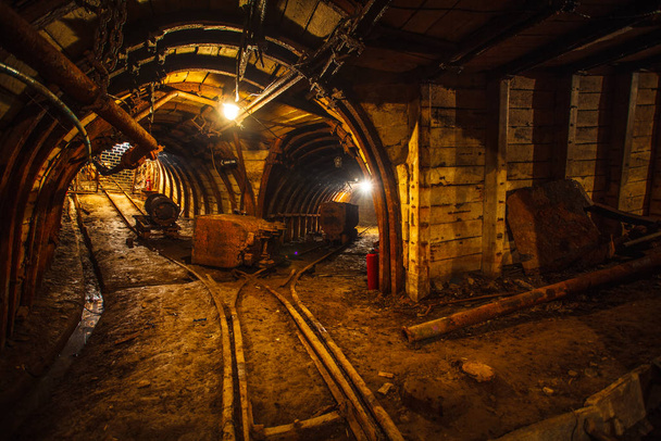 Túnel mineiro subterrâneo com carris. Espaço para cópia. Trabalho numa mina de carvão subterrânea
 - Foto, Imagem