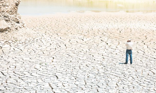 Man with a camera at the bottom of a dried lake - Photo, Image