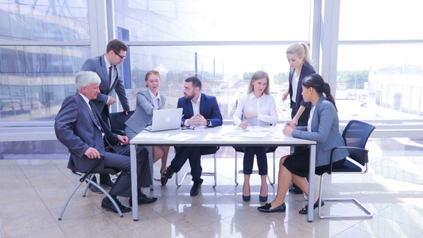 Équipe d'affaires venant à la salle de conférence dans le bureau, assis autour de la table avec ordinateur portable et documents, laps de temps
 - Séquence, vidéo