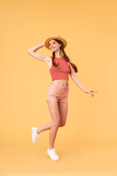 Young cheerful beautiful redhead woman posing isolated over yellow background. - Foto, Imagem