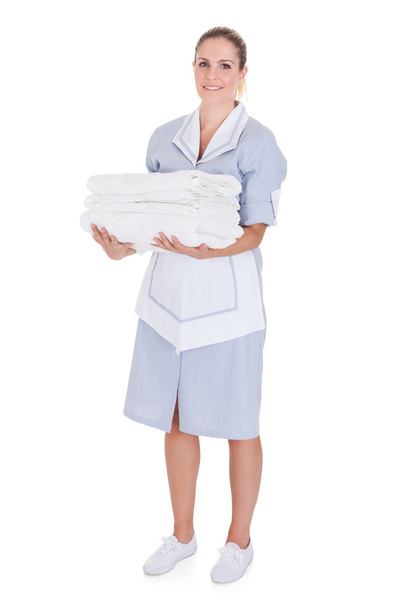 χαρούμενος νεαρός υπηρέτρια εκμετάλλευση πετσέτες - Φωτογραφία, εικόνα