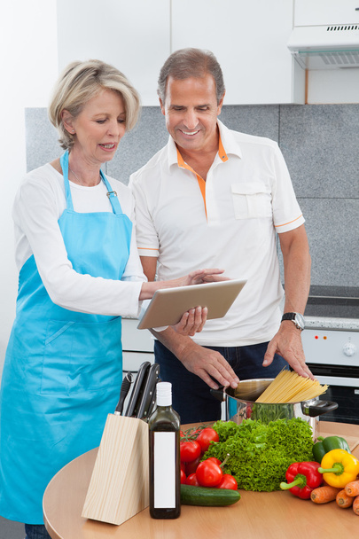 Mature Couple Using Tablet While Cooking - Photo, Image