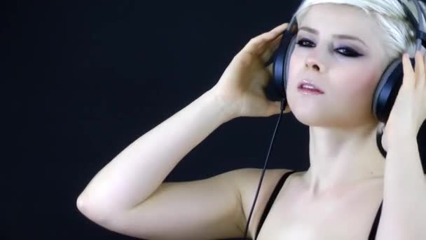 blond kobieta słuchania muzyki z słuchawek - Materiał filmowy, wideo