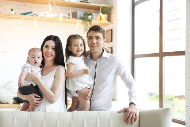 Happy young parents with their adorable little kids at home - Foto, Imagen
