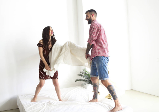 Young tattooed stylish couple hugging in bedroom - Photo, Image
