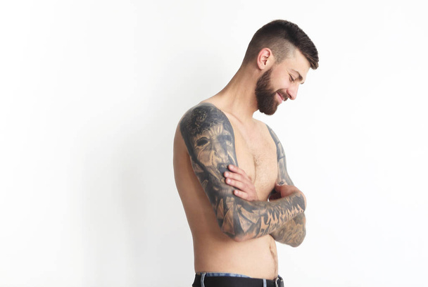 Модний без сорочки чоловік з татуюванням позує в джинсах
 - Фото, зображення