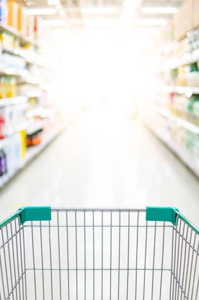 Empty shopping cart in supermarket aisle - Photo, Image