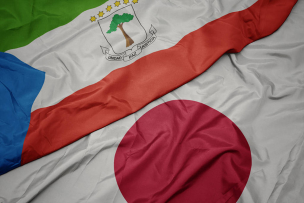 acenando bandeira colorida do japão e bandeira nacional da Guiné Equatorial
. - Foto, Imagem