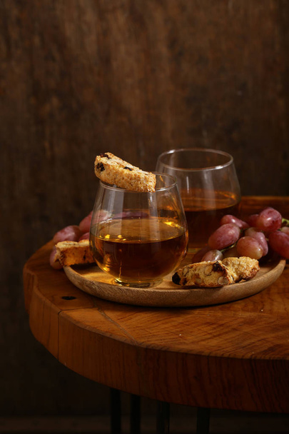 dessert white wine and biscotti on a wooden table - Photo, Image