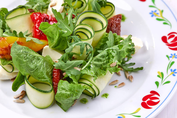 Zucchini-Rollen mit frischem Salat auf weißem Teller, Nahaufnahme  - Foto, Bild