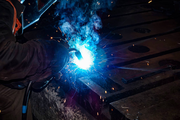 Svářeč vyrábí kovové konstrukce z kovových výrobků a spojuje je svařovacím. - Fotografie, Obrázek