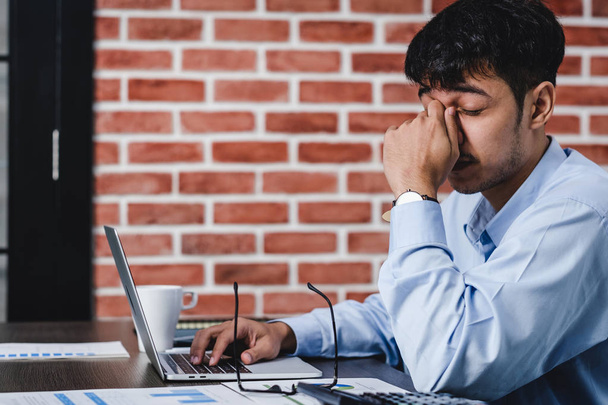 Ασιάτης επιχειρηματίας να πάρει το άγχος και κεφαλαλγία κατά την εργασία με LAPT - Φωτογραφία, εικόνα