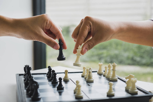 ręka trzyma kawałki szachów na pokładzie z białym tle, napędzany do sukcesu Strategia biznesowa - Zdjęcie, obraz