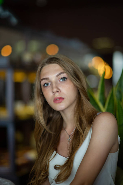 Dívka s modrými zraky sedící na městské kavárně. žena s hnědým účesu. Koncepce životního stylu. - Fotografie, Obrázek